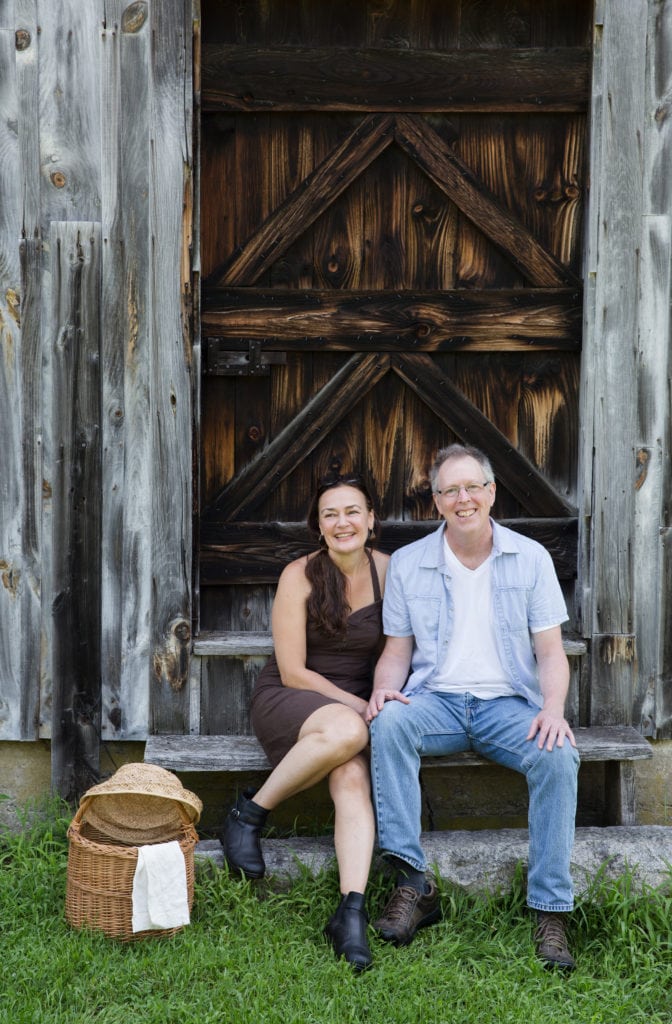 Dar Tavernier-Singer and John Singer of Tavernier Chocolates in front of a barn at Scott Farm