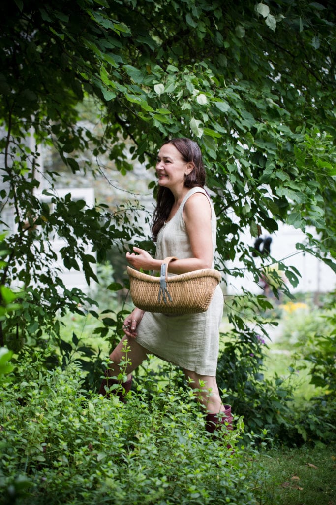 Dar Tavernier walking through trees holding a wicker basket