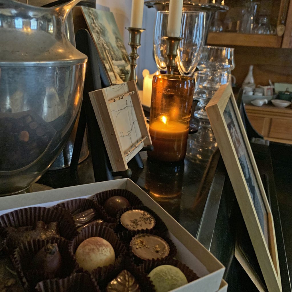 box of tavernier chocolates next to an orange candle and picture frame