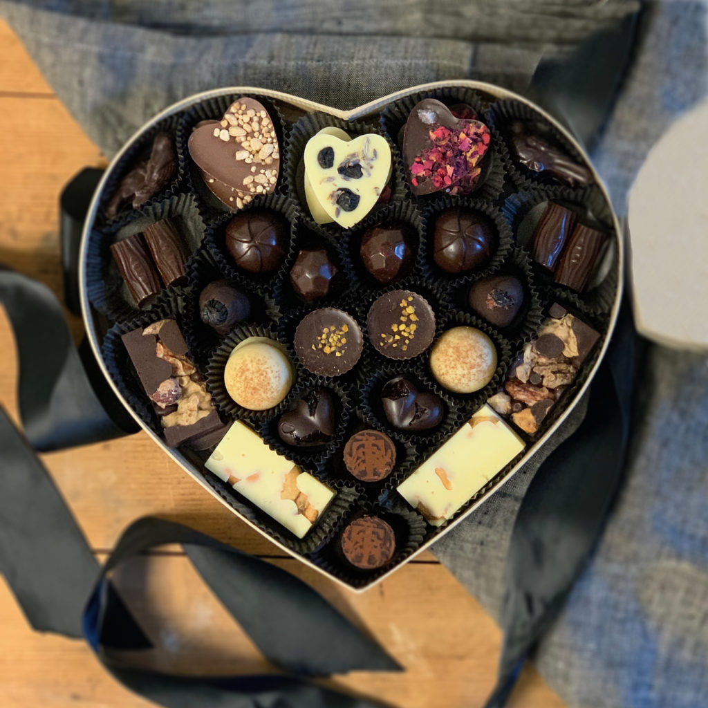 Large golden heart-shaped box filled with a collection of Tavernier bonbons