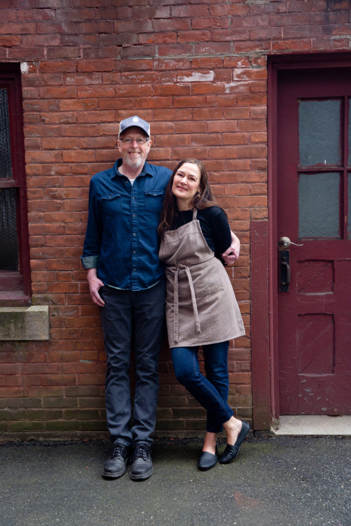 Dar and John Singer standing in front of a brick wall