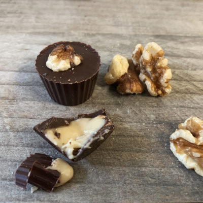 Vermont maple cream in a dark chocolate cup with a toasted salted walnut