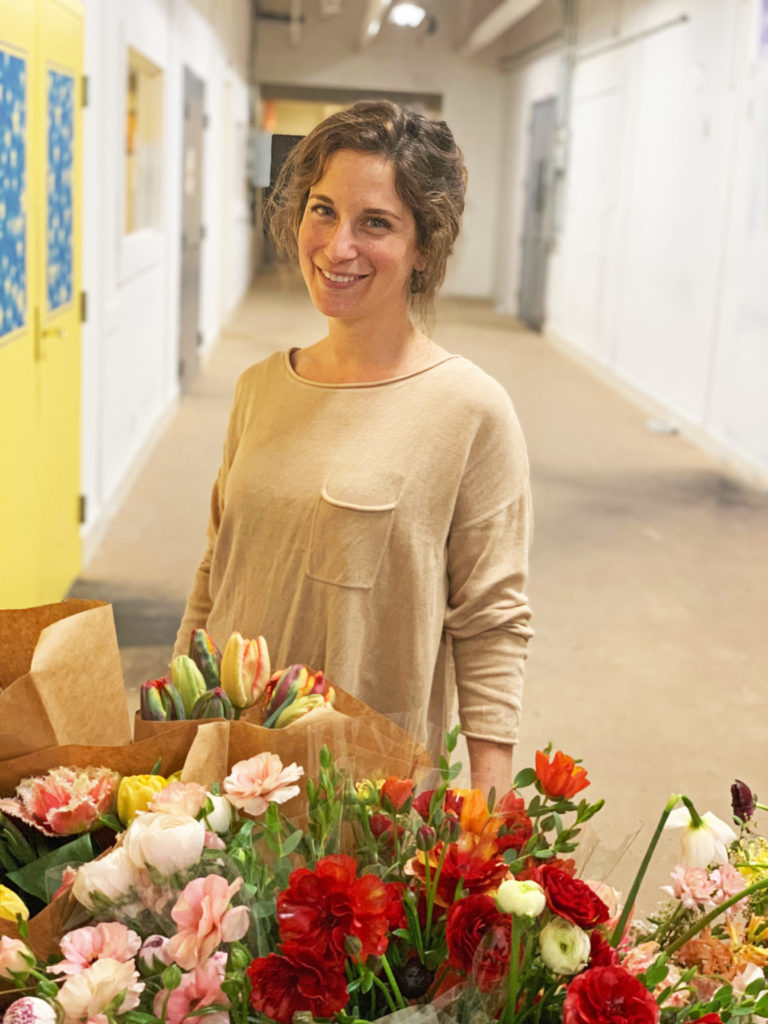 Young woman with a table filled with flower bouquets