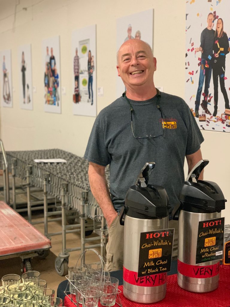 Man smiling next to coffee dispensers