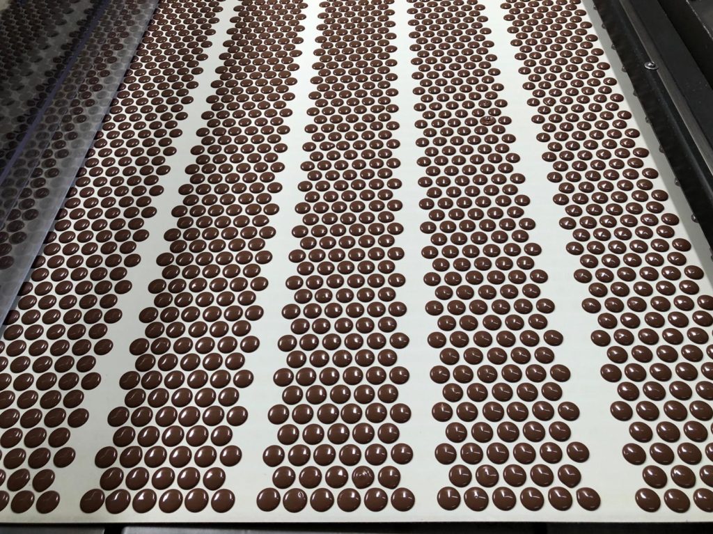 Chocolates being molded in a large system