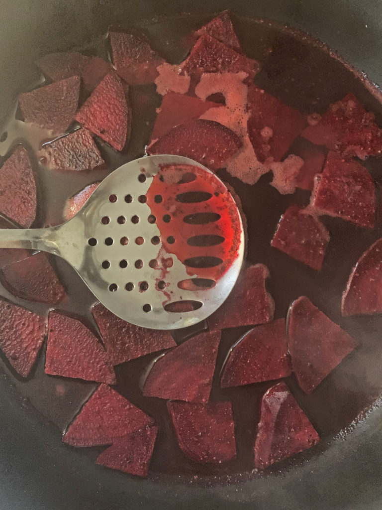 Overhead shot of sliced beets cooking in a pan
