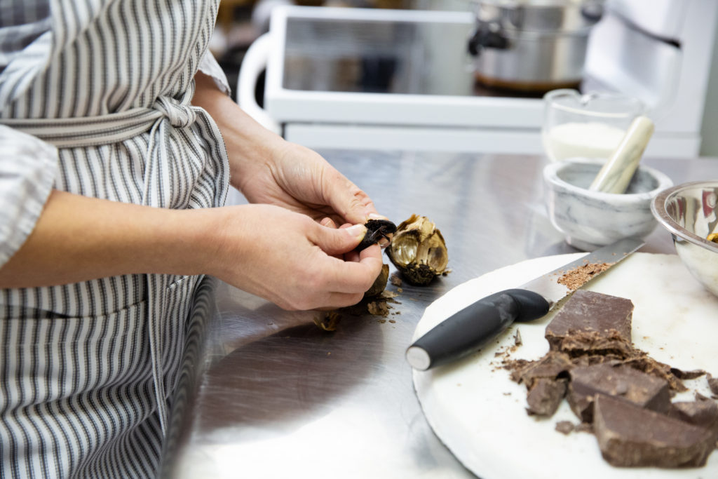 Hands working with foraged mushrooms and raw chocolate