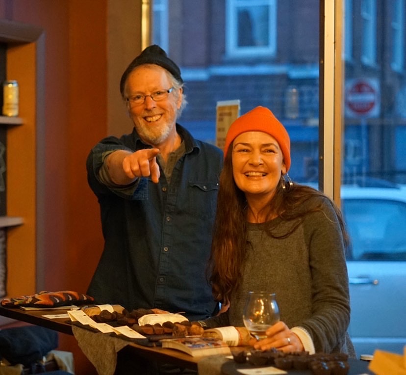 John and Dar Singer smiling and laughing at an event at Hermit Thrush Brewery