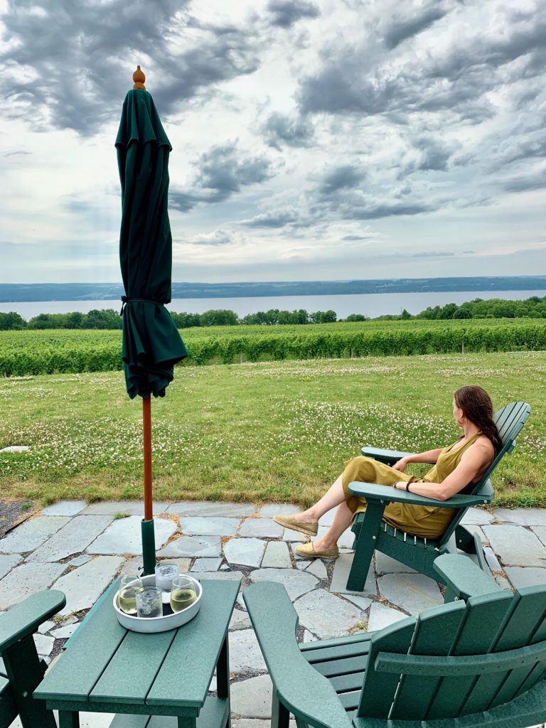 View of the finger lakes. Dar is seated in an Adirondack chair looking out at the water