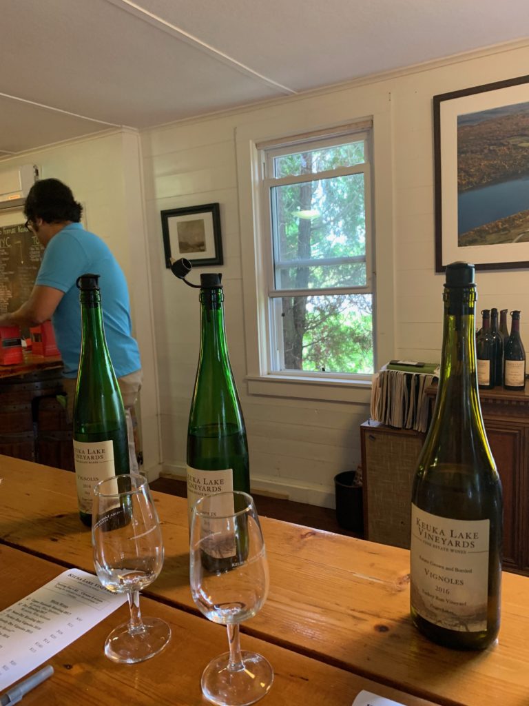 Three wine bottles and glass at a wine tasting in New York wine country