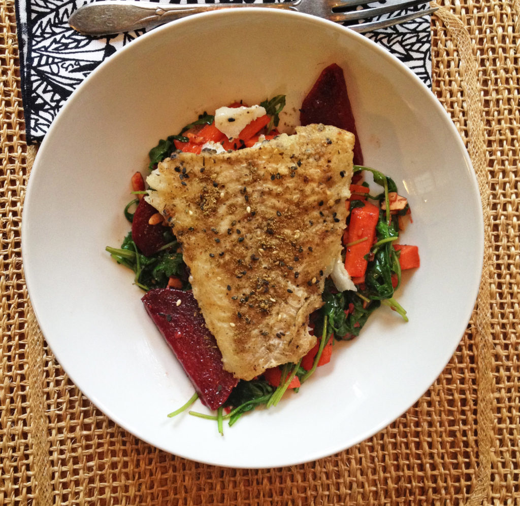 Plated fish with a salad of beets, carrots, and cheese