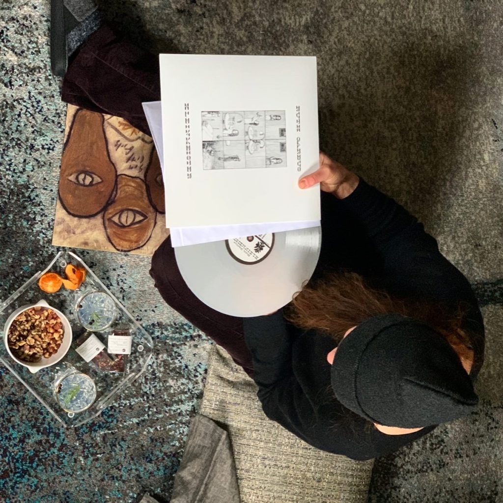 Overhead of a woman holding a record and the record's case