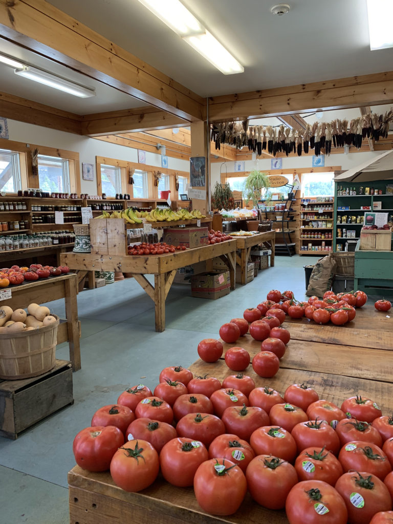 Interior of Dutton Farms farmstand with lots of fresh tomatos and bananas