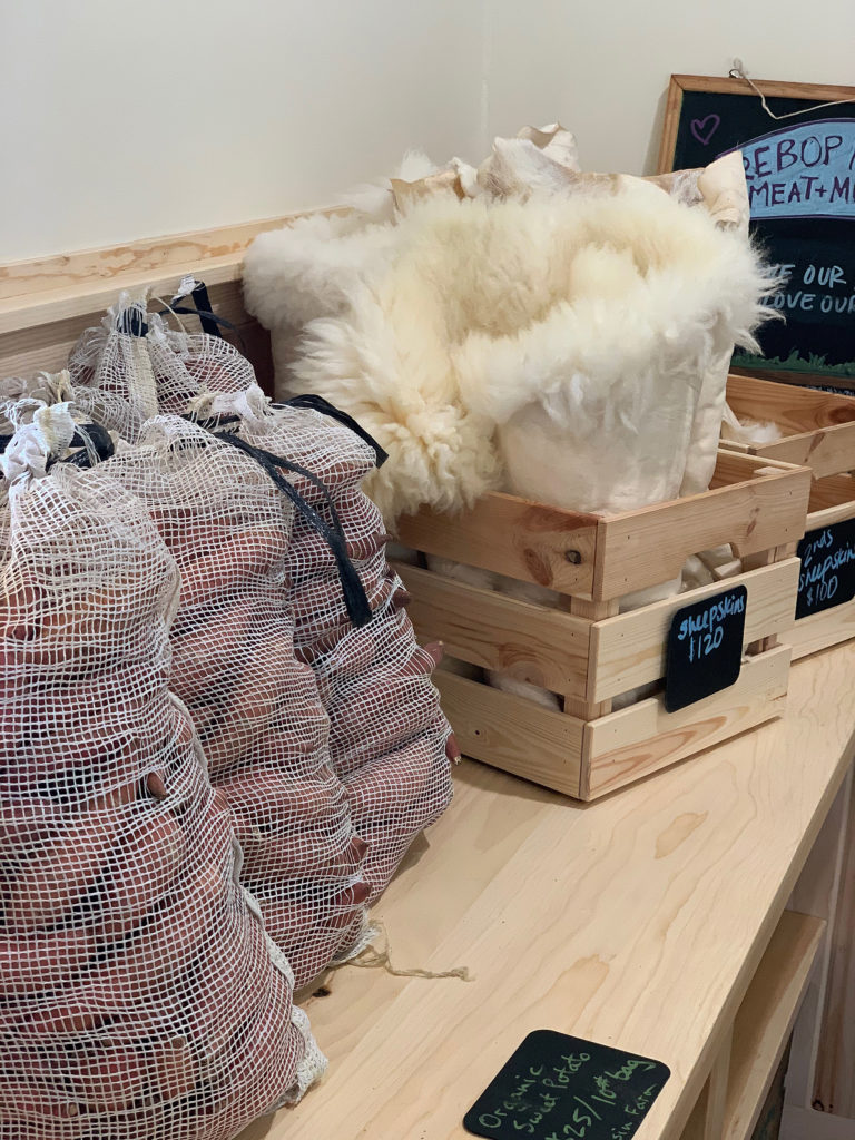 Wooden box filled with sheep skins and mesh bags of sweet potatos