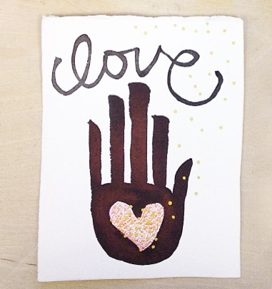 Art with the word love written in cursive and a black outstretched hand with a pink heart in the palm