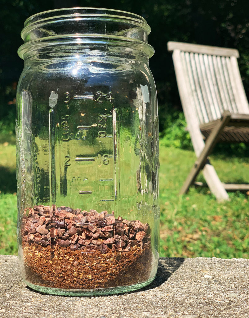 Mason jar filled with coffee and cocoa nibs outside