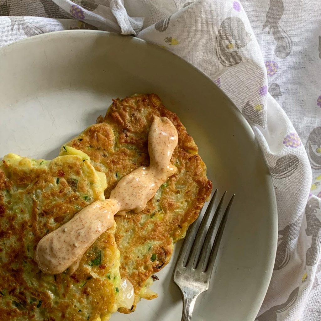 Plate with two fritters topped with an remoulade