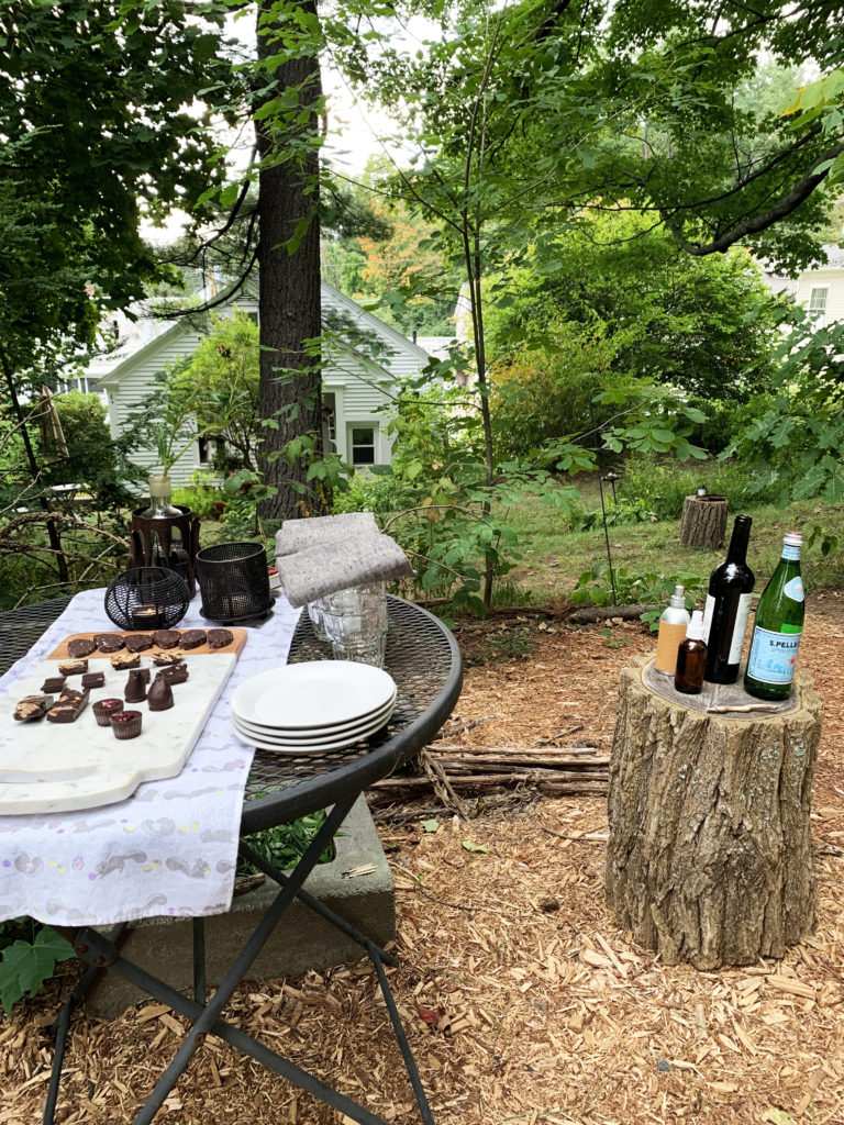 Outdoor black wire table with a marble cheese board with Tavernier Chocolates. 