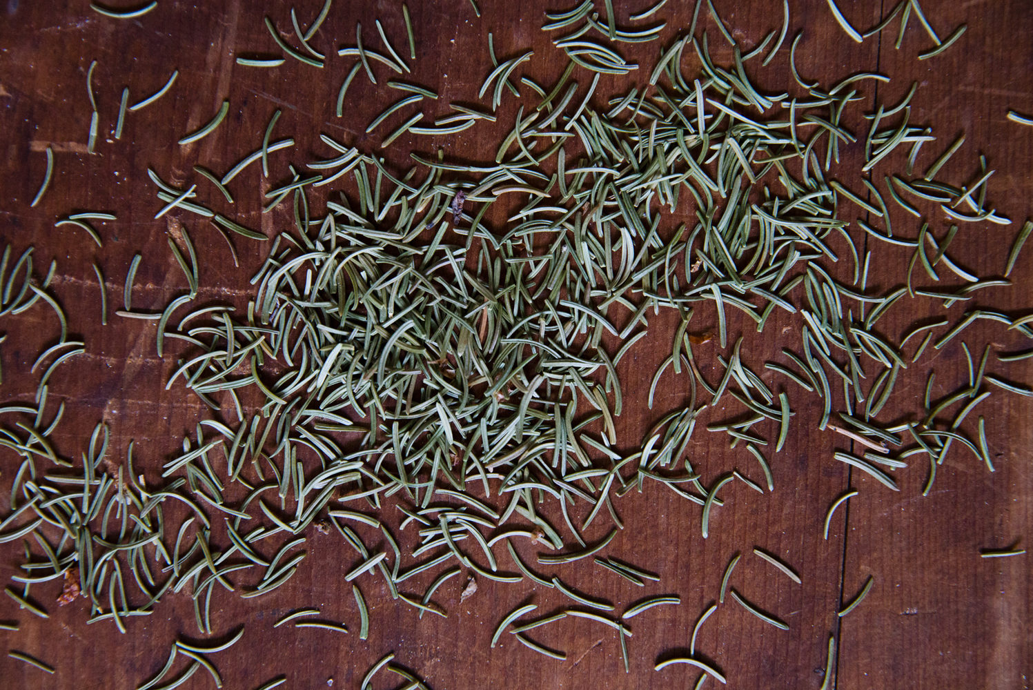 Pine needles scattered on a dark wooden table