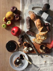 Overhead shot of a cheese board with bread, figs, pine nuts, and Tavernier chocolate charcuterie. 