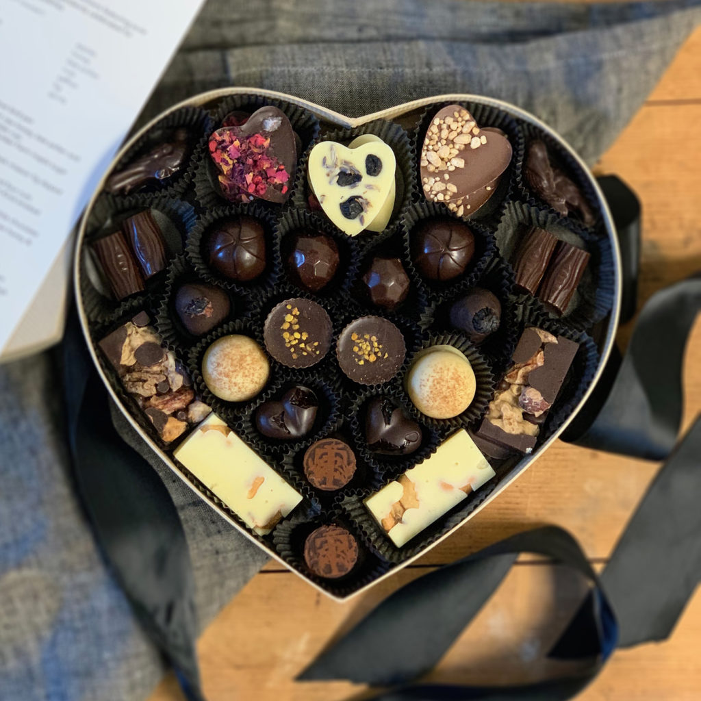 Large golden heart-shaped box filled with a collection of Tavernier bonbons
