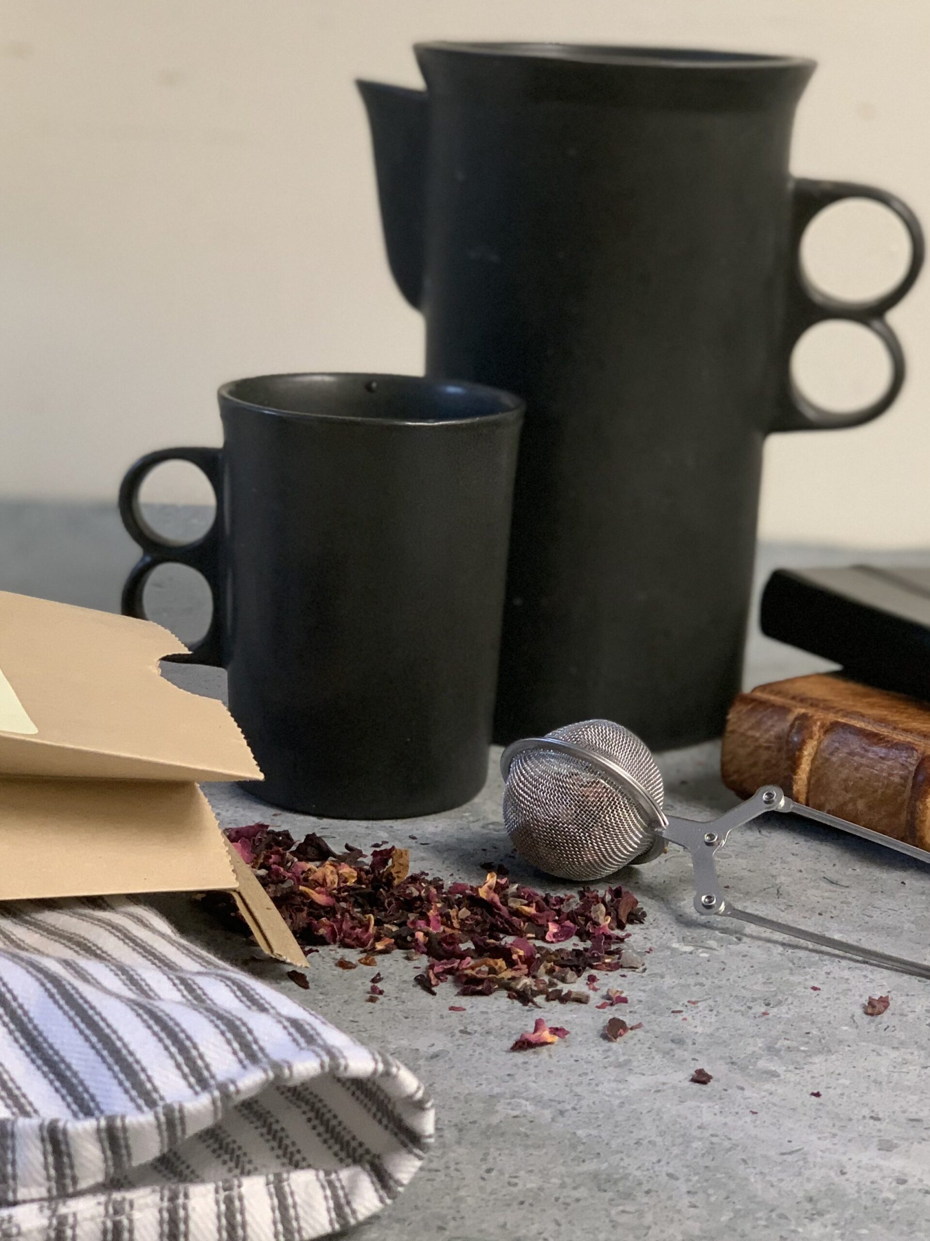 Two black coffee mugs, one large and small small. 