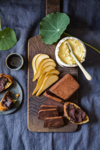 chocolate pate sliced on a wooden board with pears, soft rind cheese and schmeared on baguette slices