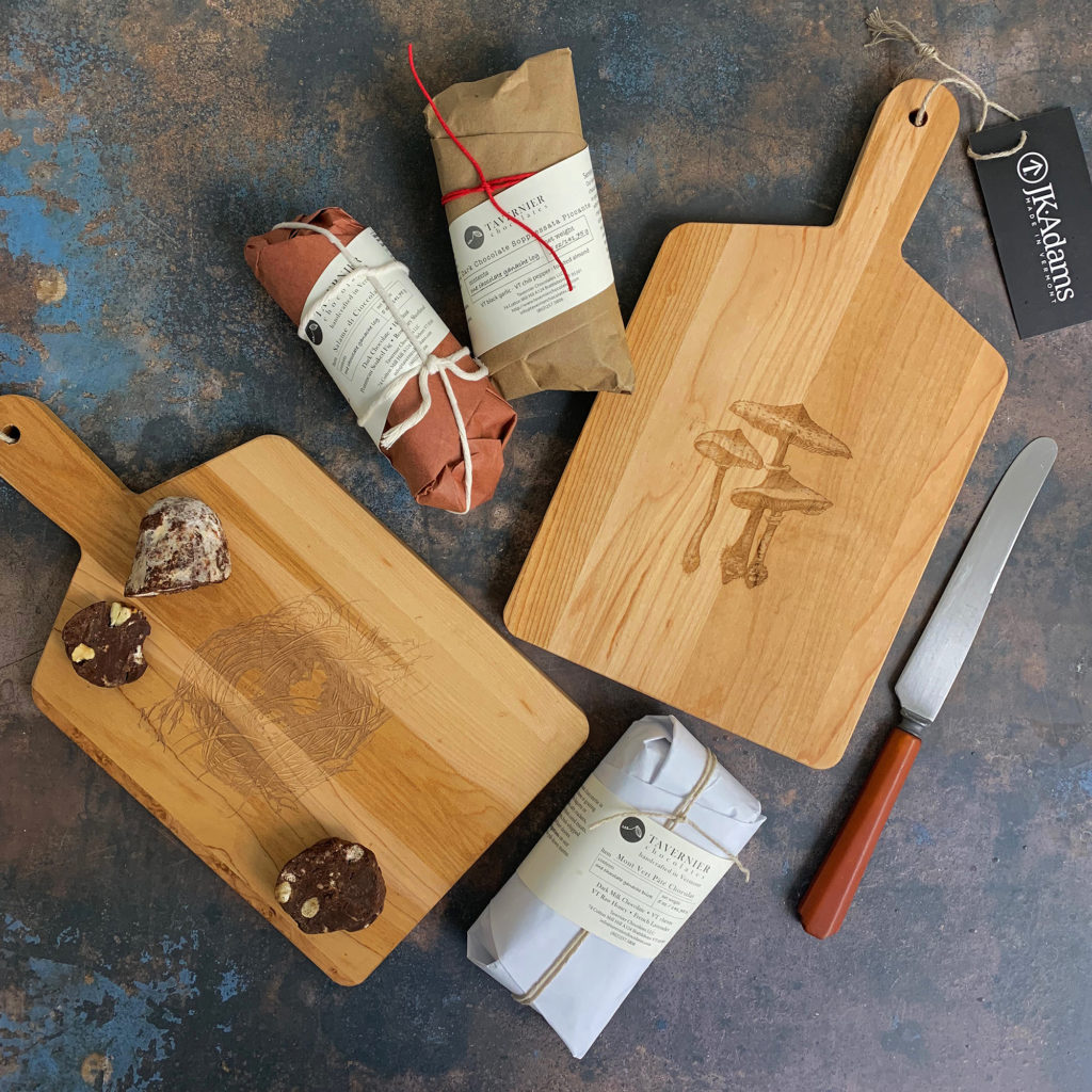Two wooden cutting boards with handles on a distressed painted background with chocolate charcuterie and a slicing knife